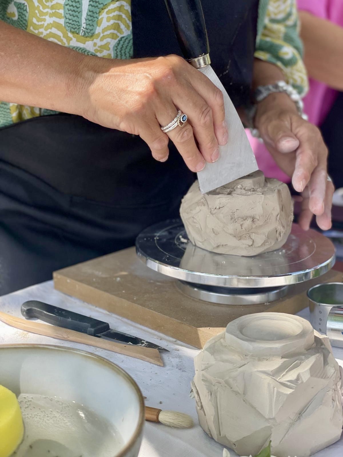 Fabrication d'un bol sculpté en argile. Kurinuki. Mains façonnant une tasse à thé